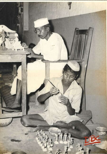 two persons colouring dolls