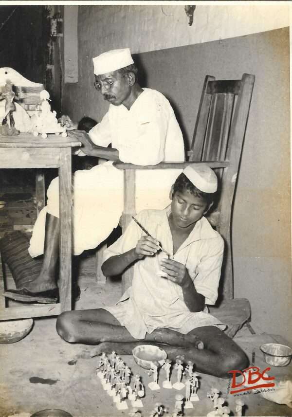 two persons colouring dolls