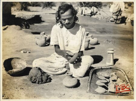 A Craftsman Hammering Clay With Stone