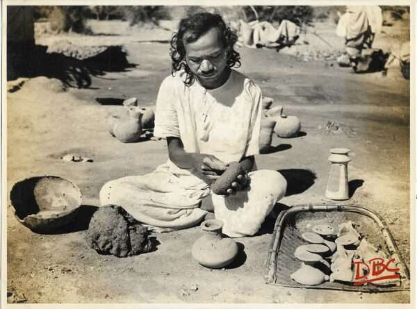 A Craftsman Hammering Clay With Stone