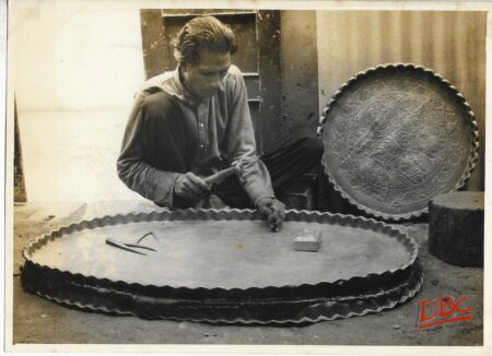 A Craftsman Working on a Huge Brass Plate