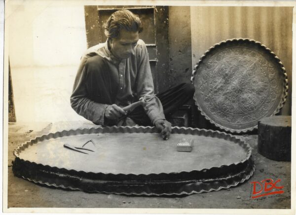 A Craftsman Working on a Huge Brass Plate